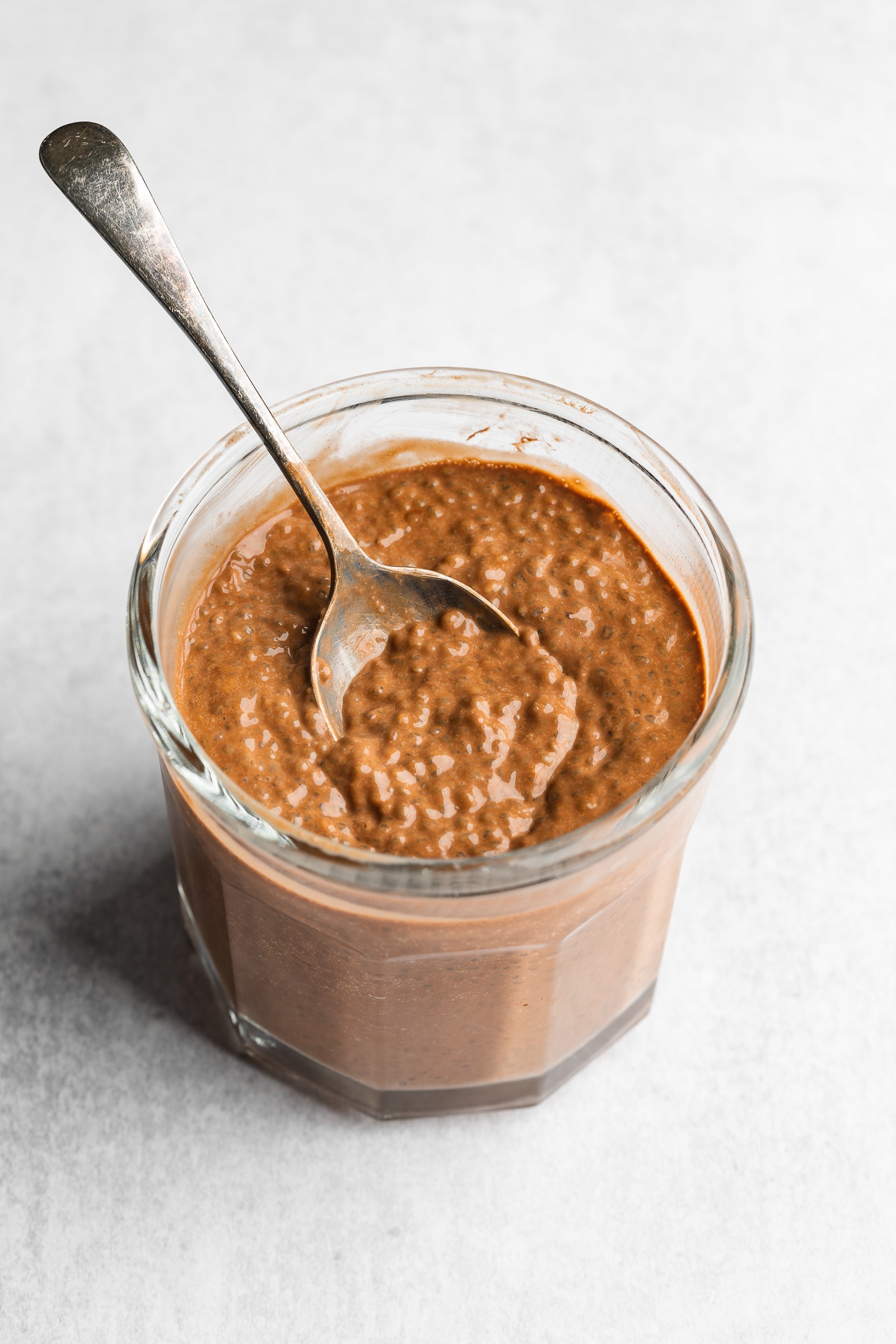 Chocolate overnight oats in a glass jar after being refrigerated overnight.