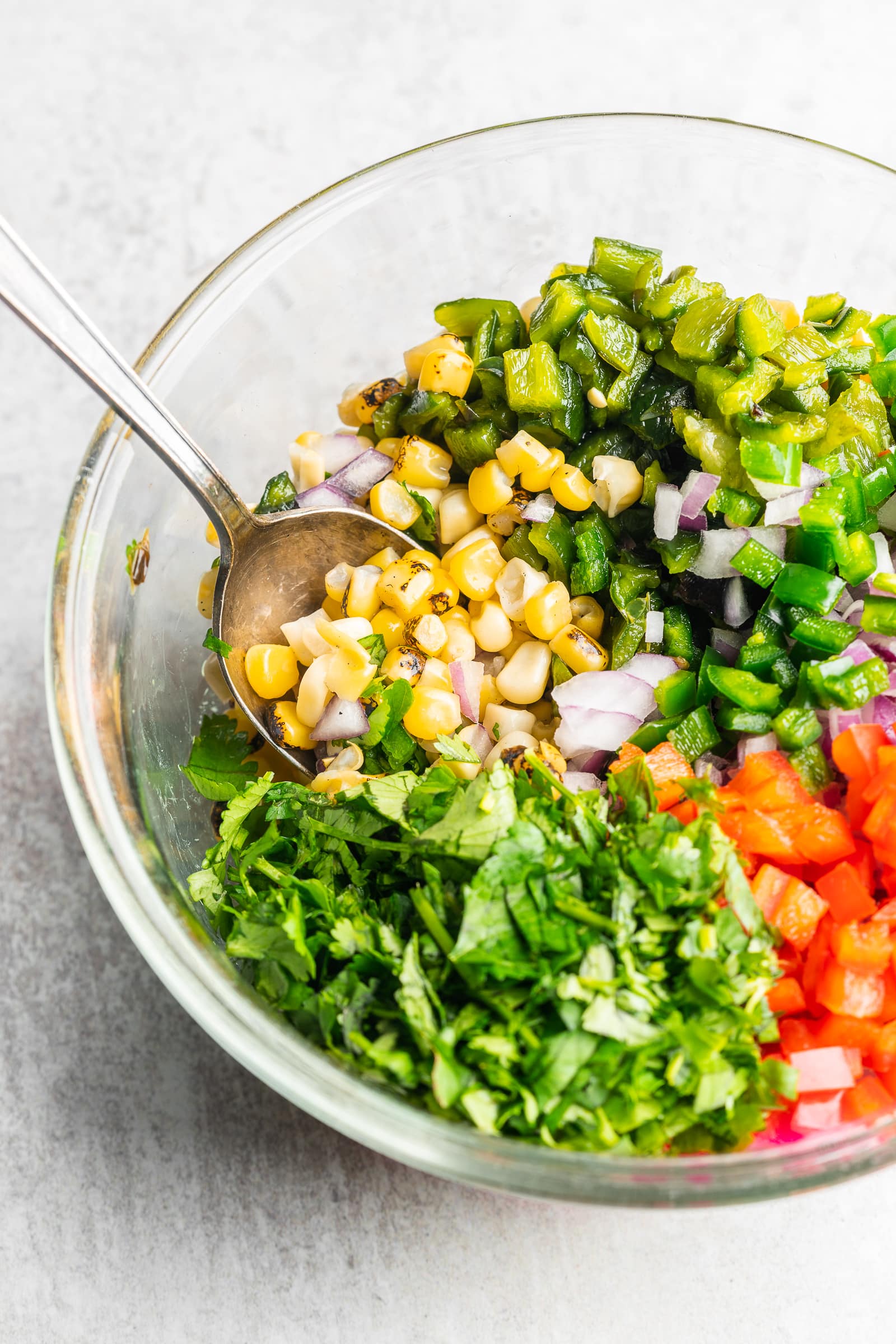Corn salsa ingredients in a glass bowl.