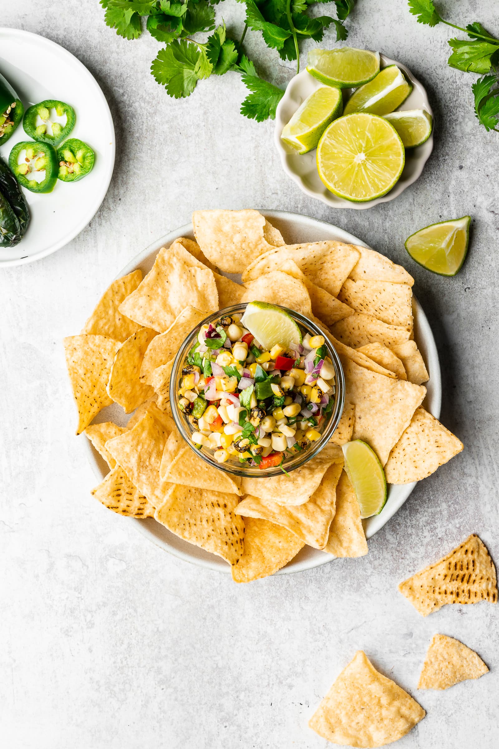 Corn salsa in a serving dish surrounded by tortilla chips.