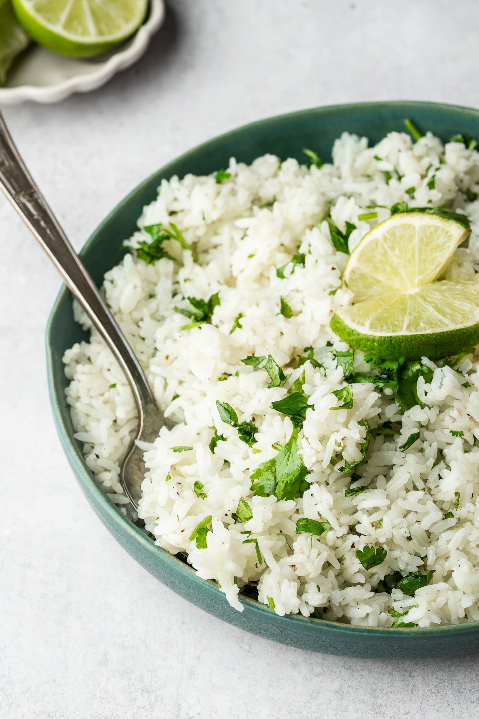 Cilantro lime rice in a serving dish garnished with lime.