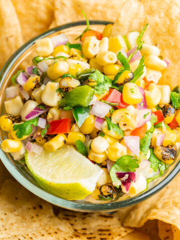 Corn salsa in a serving dish surrounded by chips.