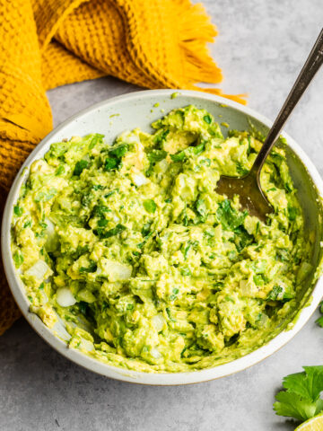 Fresh guacamole without tomatoes in a shallow bowl.