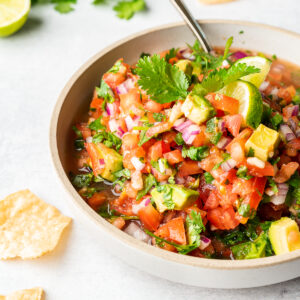 Pico de Gallo with avocado garnished with lime wedge and cilantro.