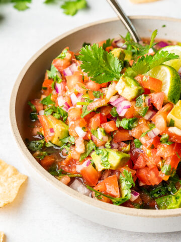 Pico de Gallo with avocado garnished with lime wedge and cilantro.