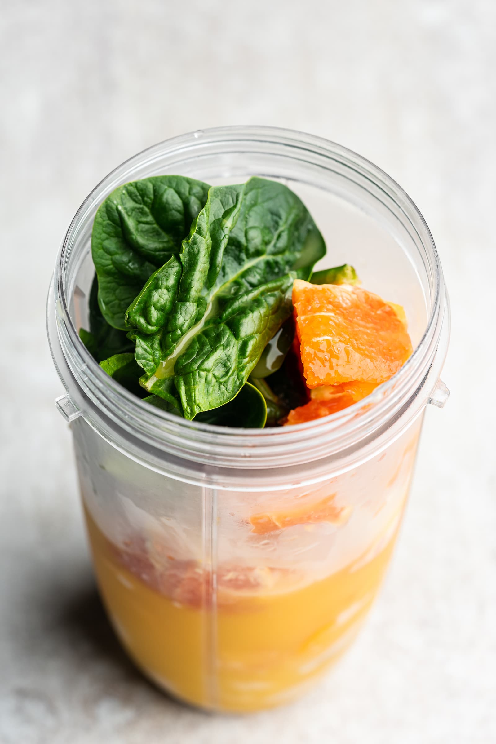 Orange spinach smoothie before being blended.