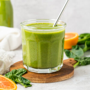 Orange spinach smoothie in a glass jar.