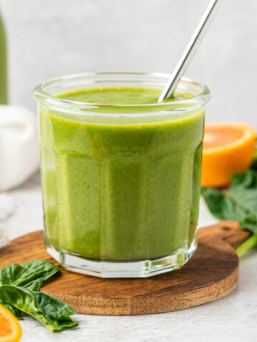Orange spinach smoothie in a glass jar.