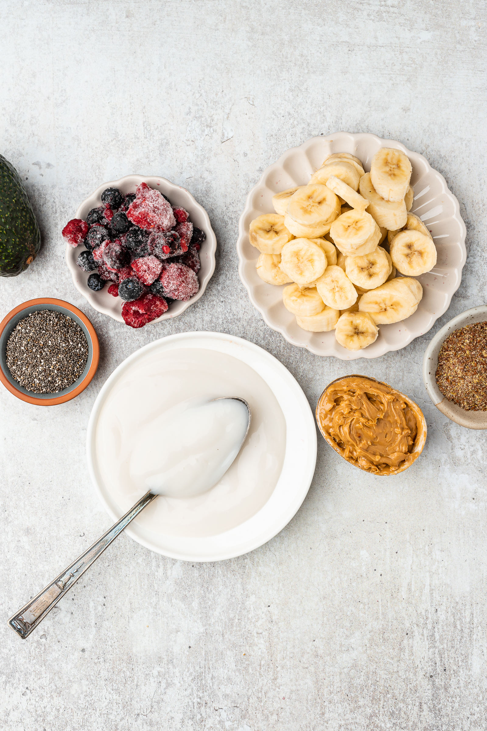 Yogurt substitutes for smoothies including sliced bananas, vegan yogurt, frozen berries, chia seeds, and peanut butter.