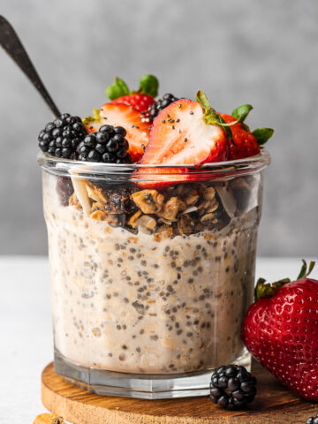 Creamy overnight oats without yogurt topping with granola, strawberries, and blackberries.