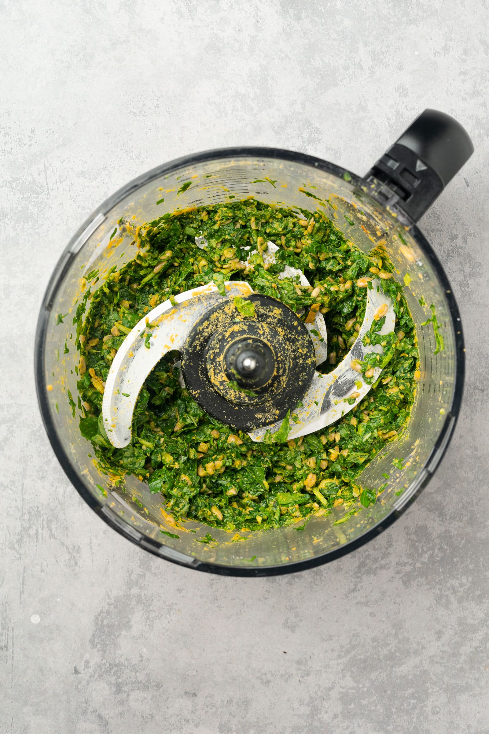 Ingredients for pesto in a food processor before adding olive oil.