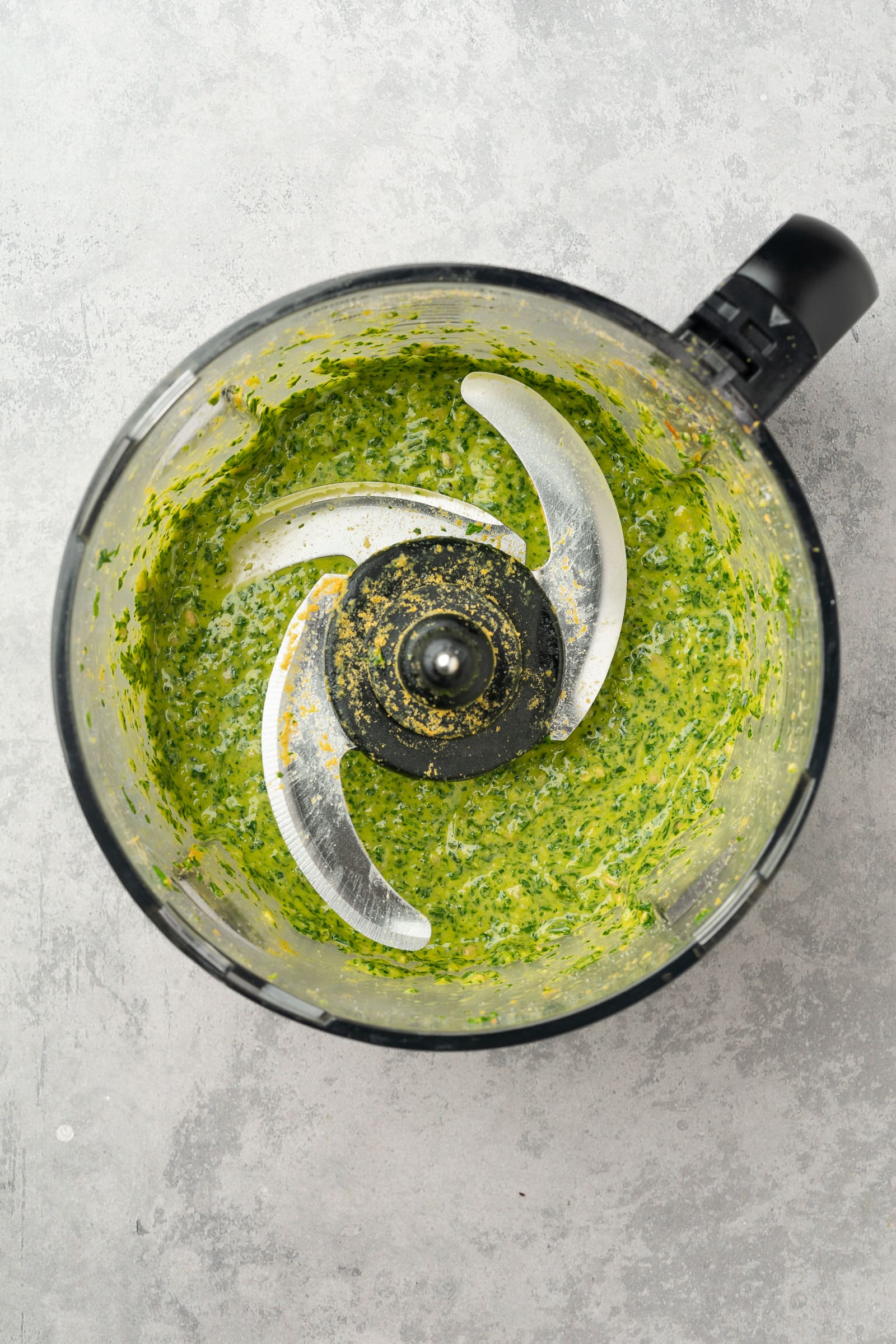 Ingredients for pesto in a food processor after processing.