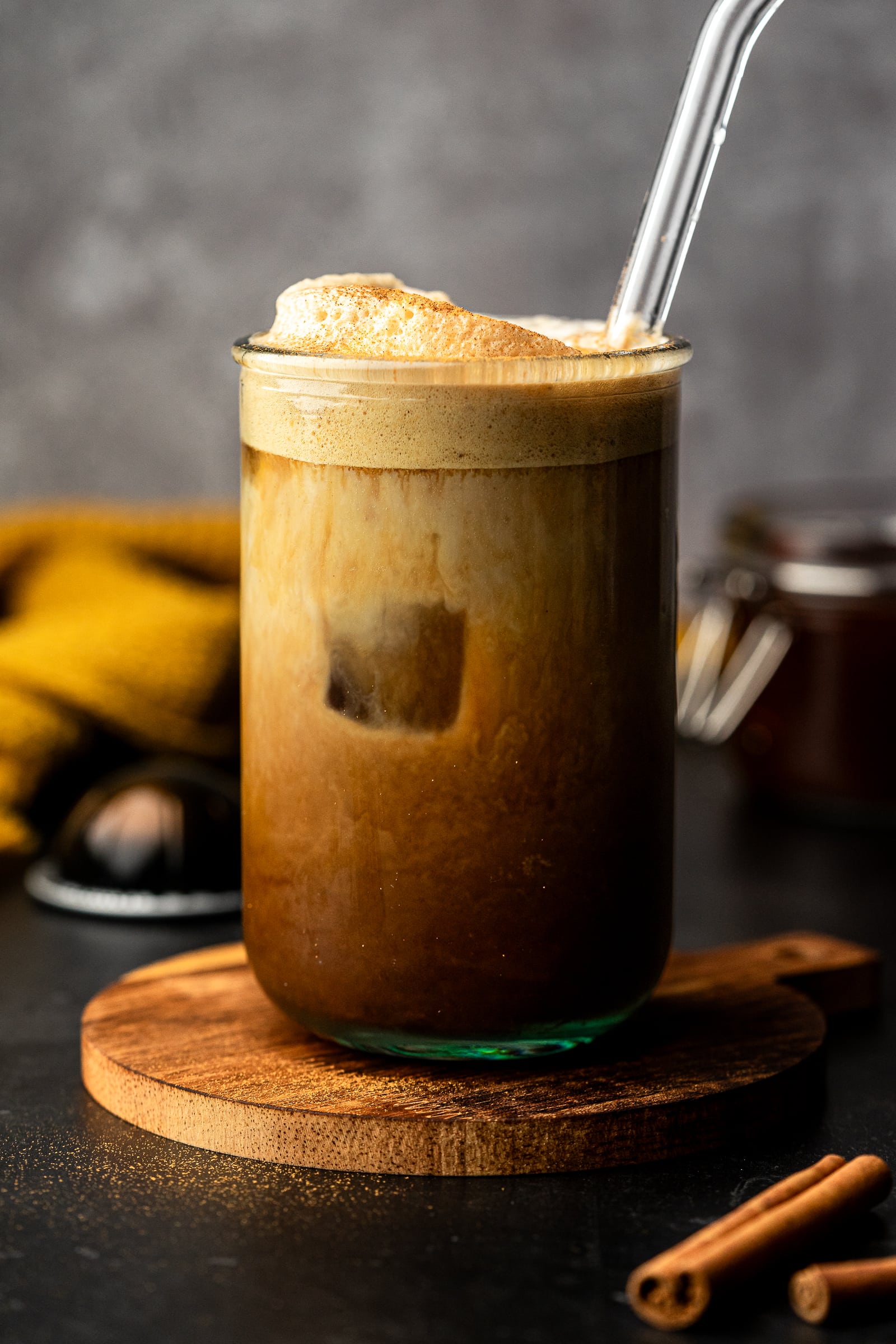 Apple crisp shaken espresso in a glass jar with a glass straw.