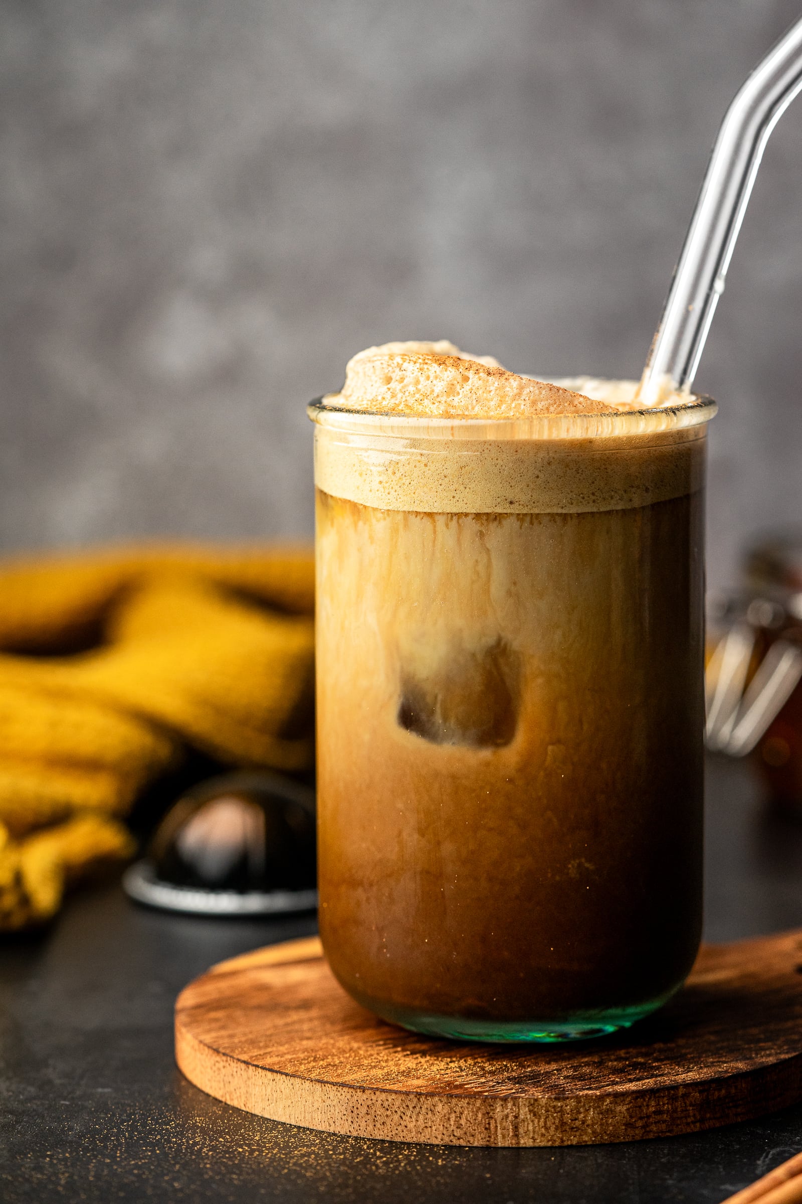 Apple crisp shaken espresso in a glass jar with a glass straw.