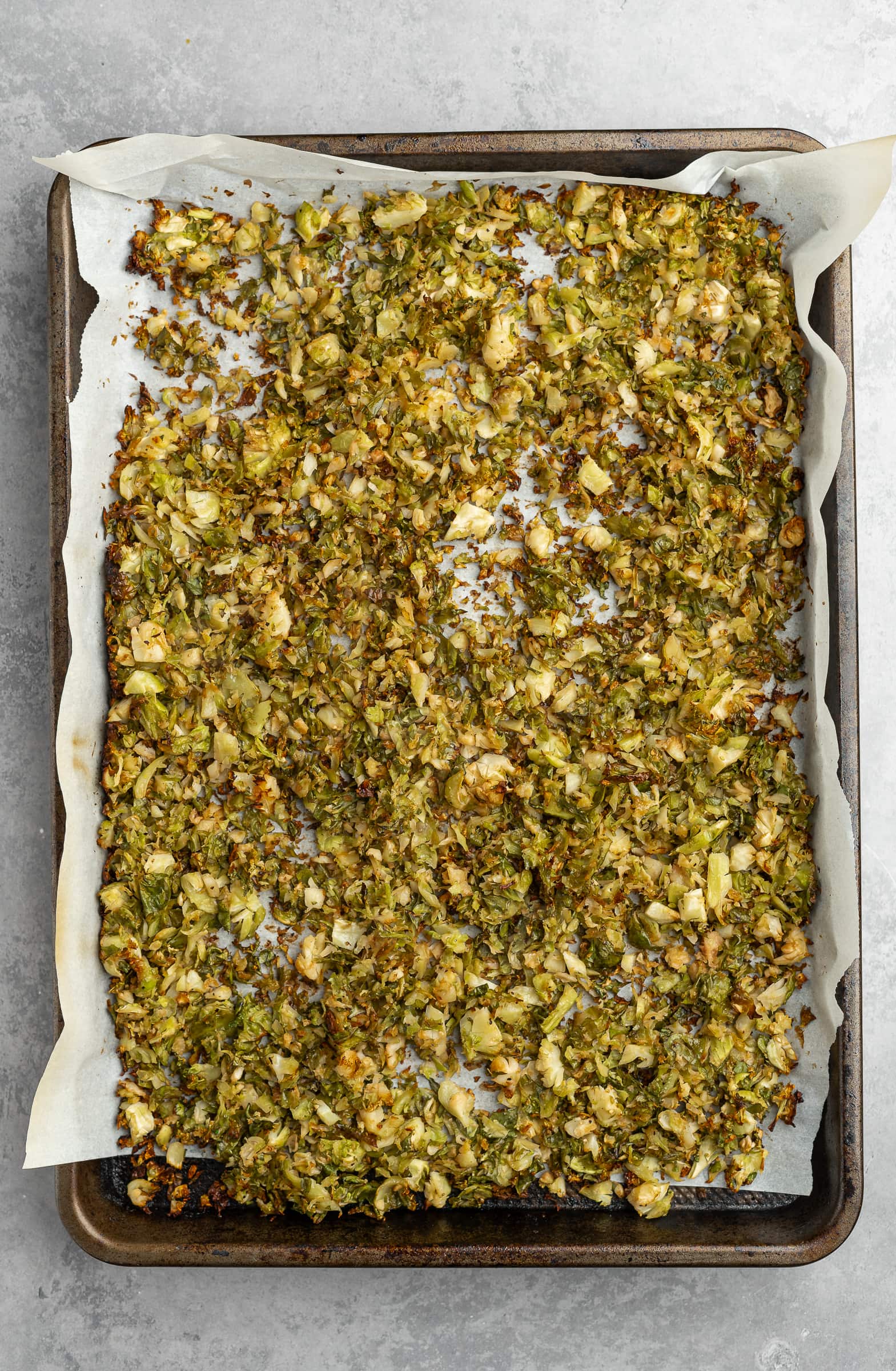 Crispy golden brown shredded Brussels sprouts on a baking tray.