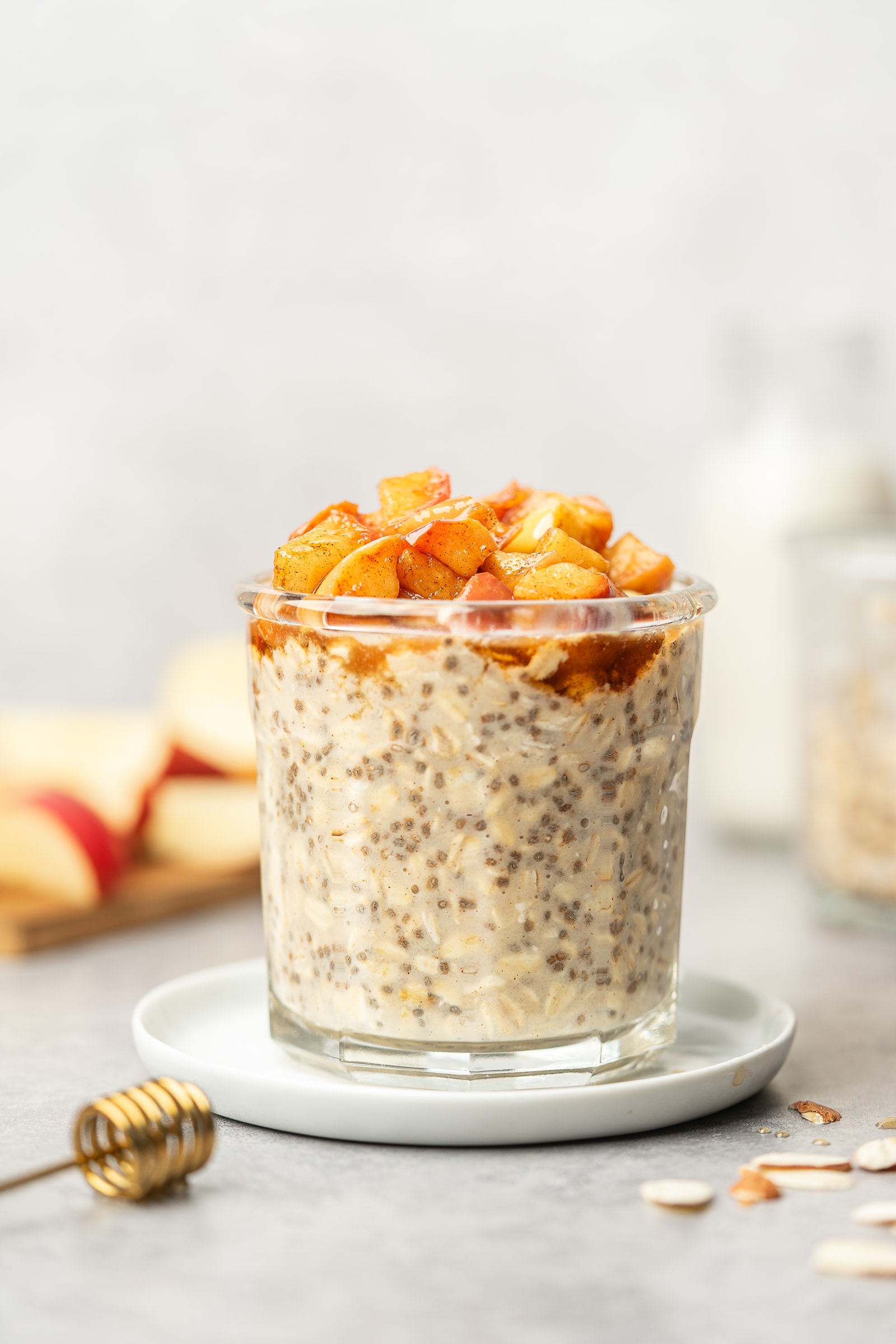 Overnight oats in a glass jar topped with cooked cinnamon apples.