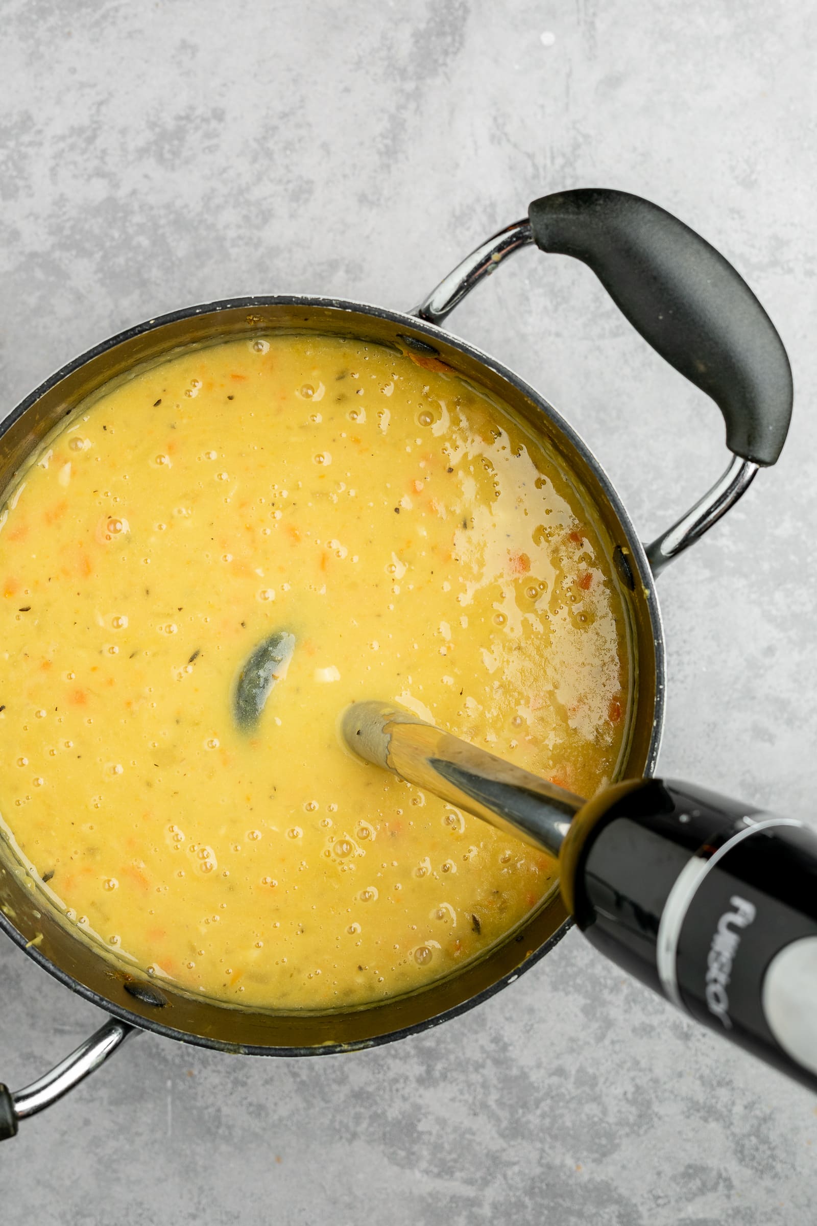 Soup being blended with an immersion blender.