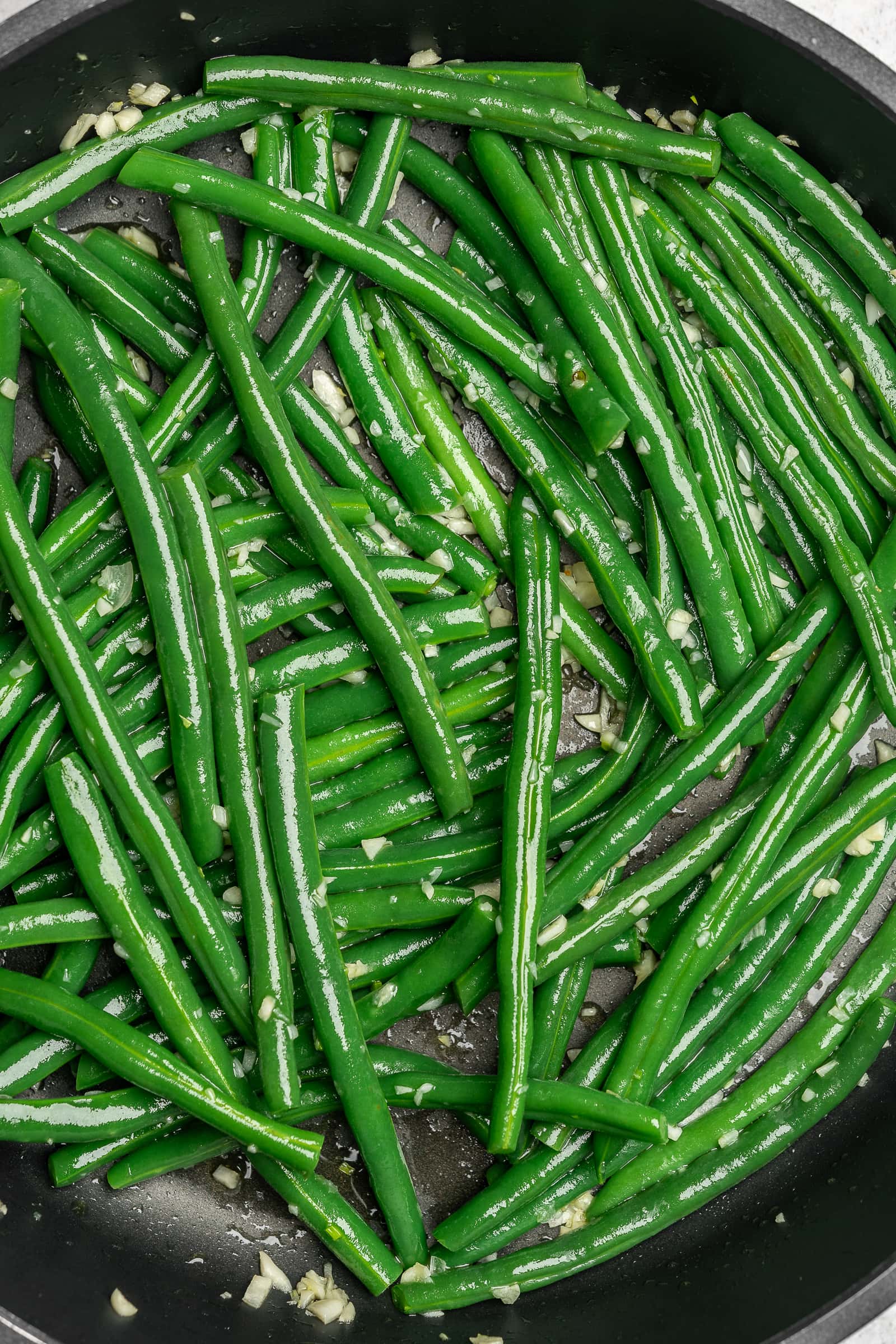 Garlic green beans in a frying pan.