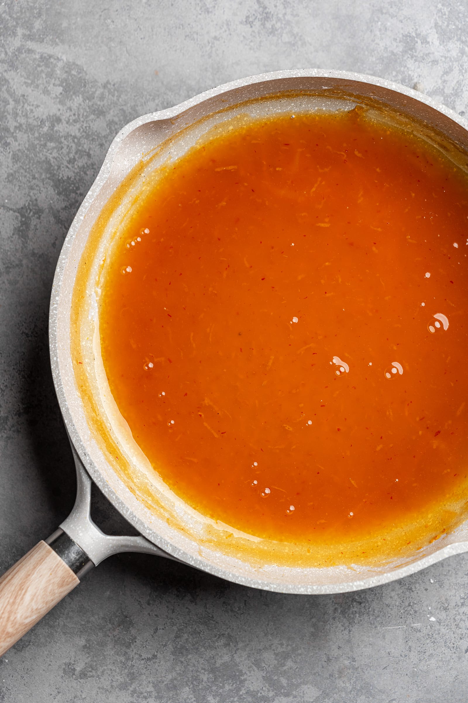 Orange sauce in a pan after simmering.