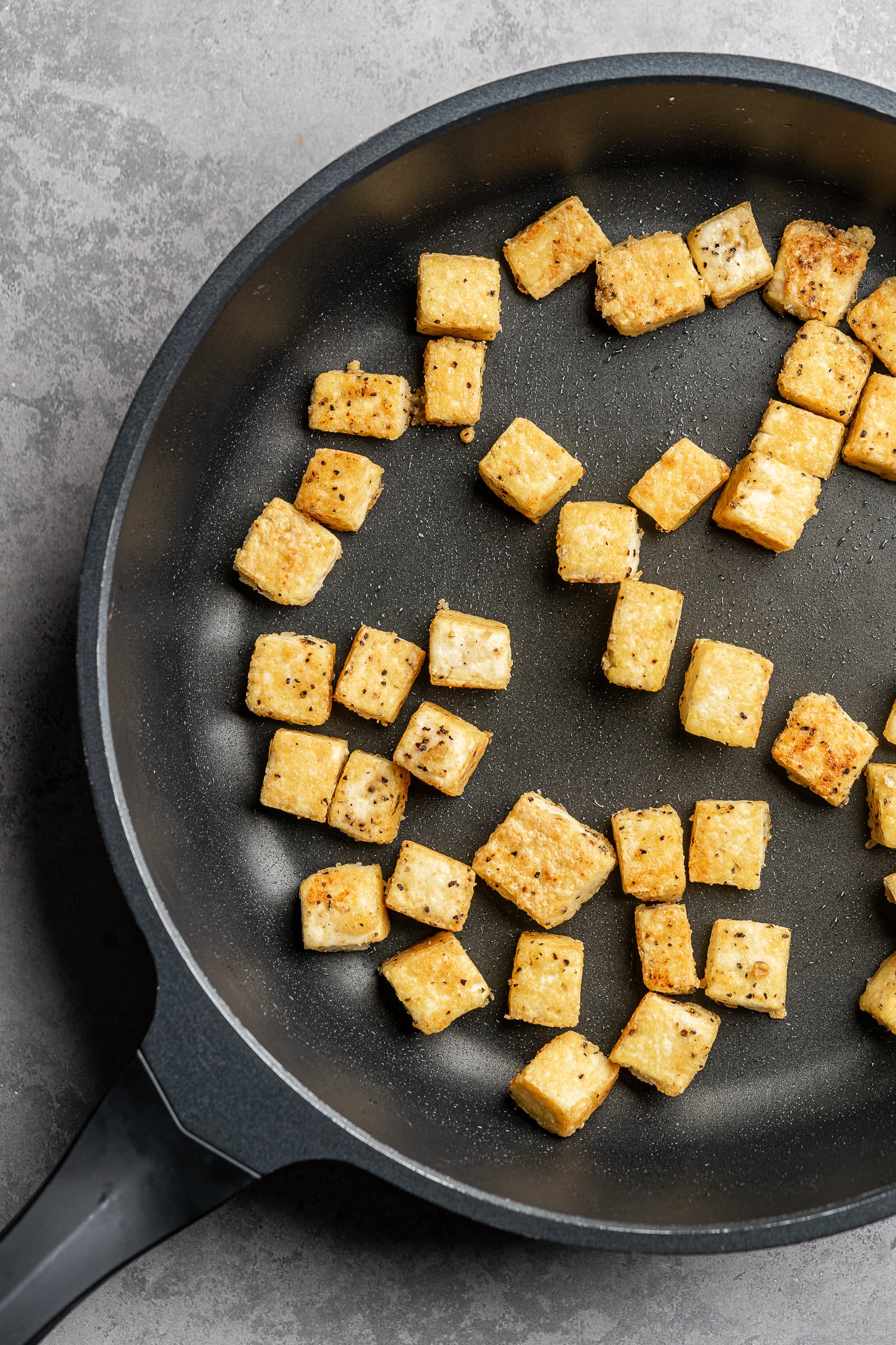 Crispy tofu in a frying pan.