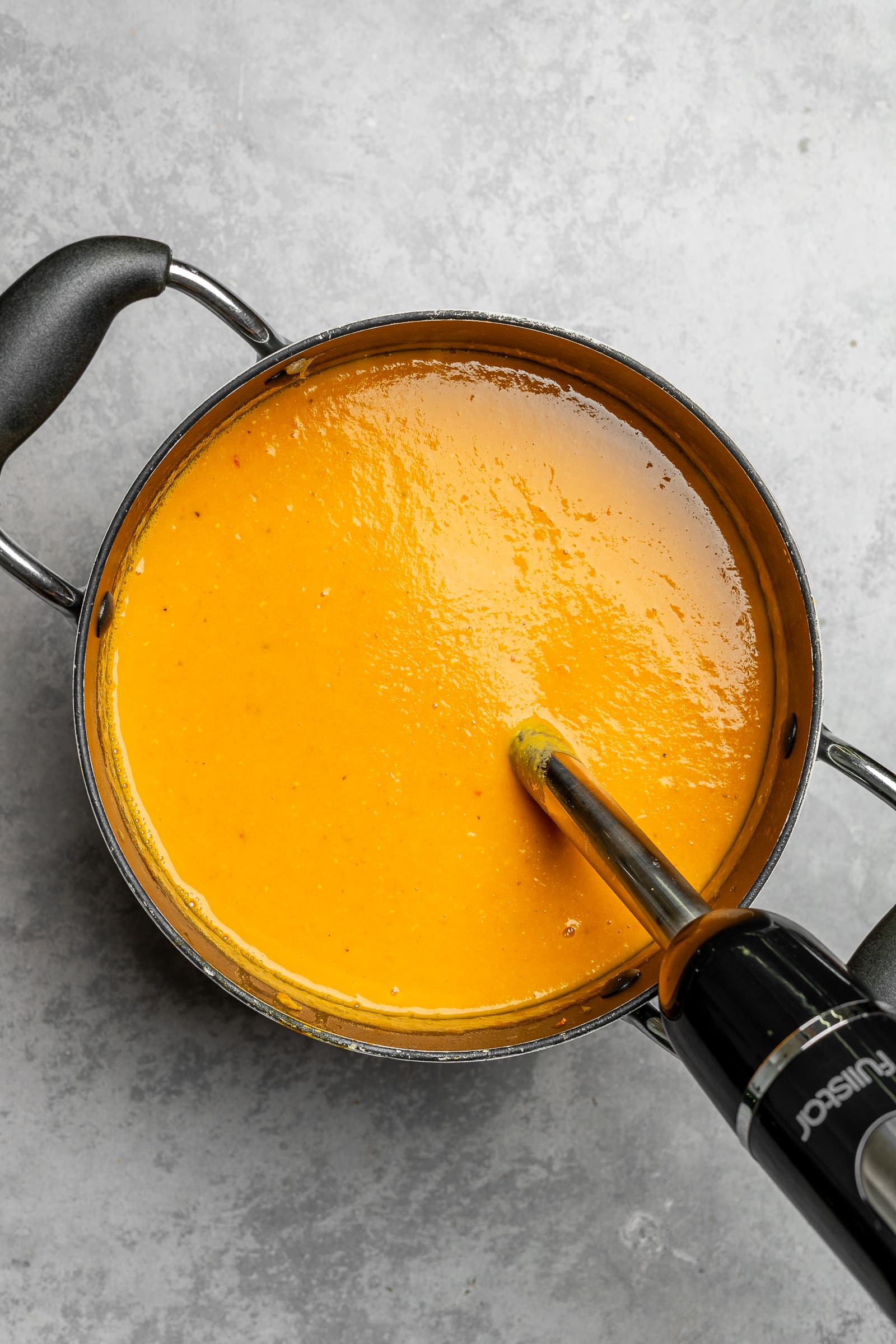 Simmered lentil carrot soup in a soup pot after blending.