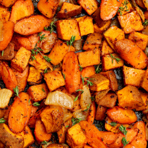Roasted sweet potatoes and carrots garnished with fresh thyme.