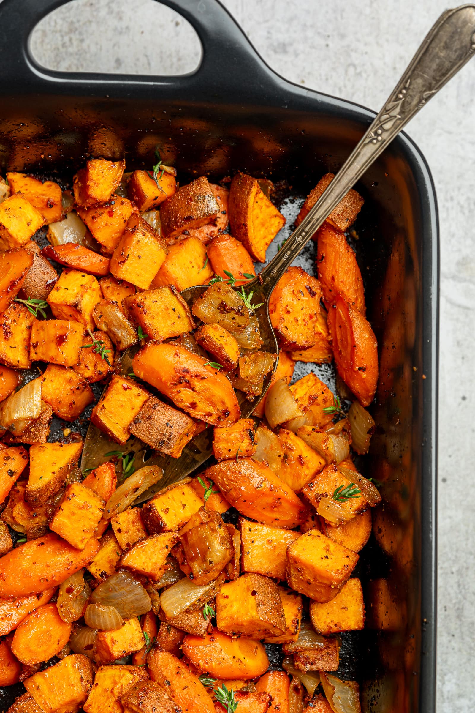 Roasted sweet potatoes and carrots garnished with fresh thyme.