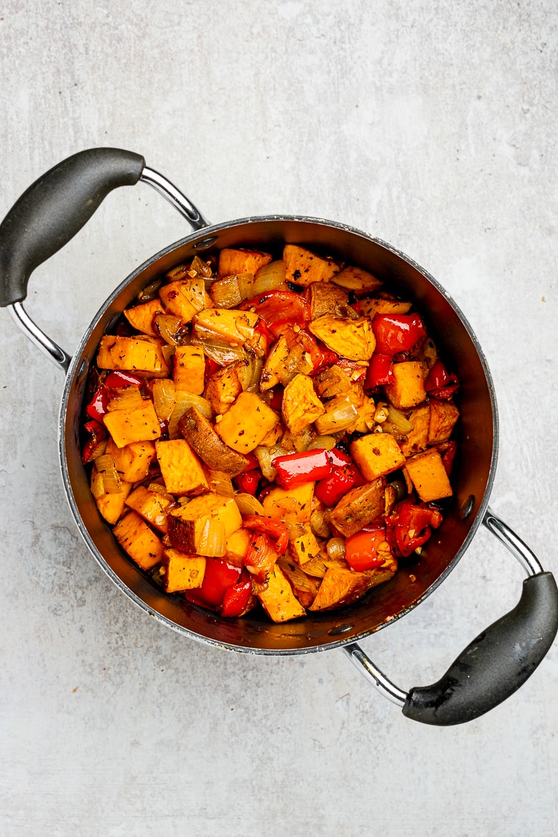 Roasted vegetables in a soup pot.