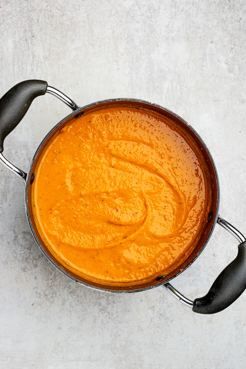 Puréed sweet potato and red pepper soup in a large pot.