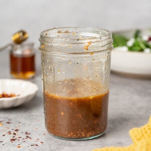 Maple balsamic dressing in a glass jar. Garnished with red chili flakes.