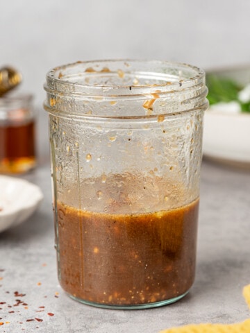 Maple balsamic dressing in a glass jar. Garnished with red chili flakes.