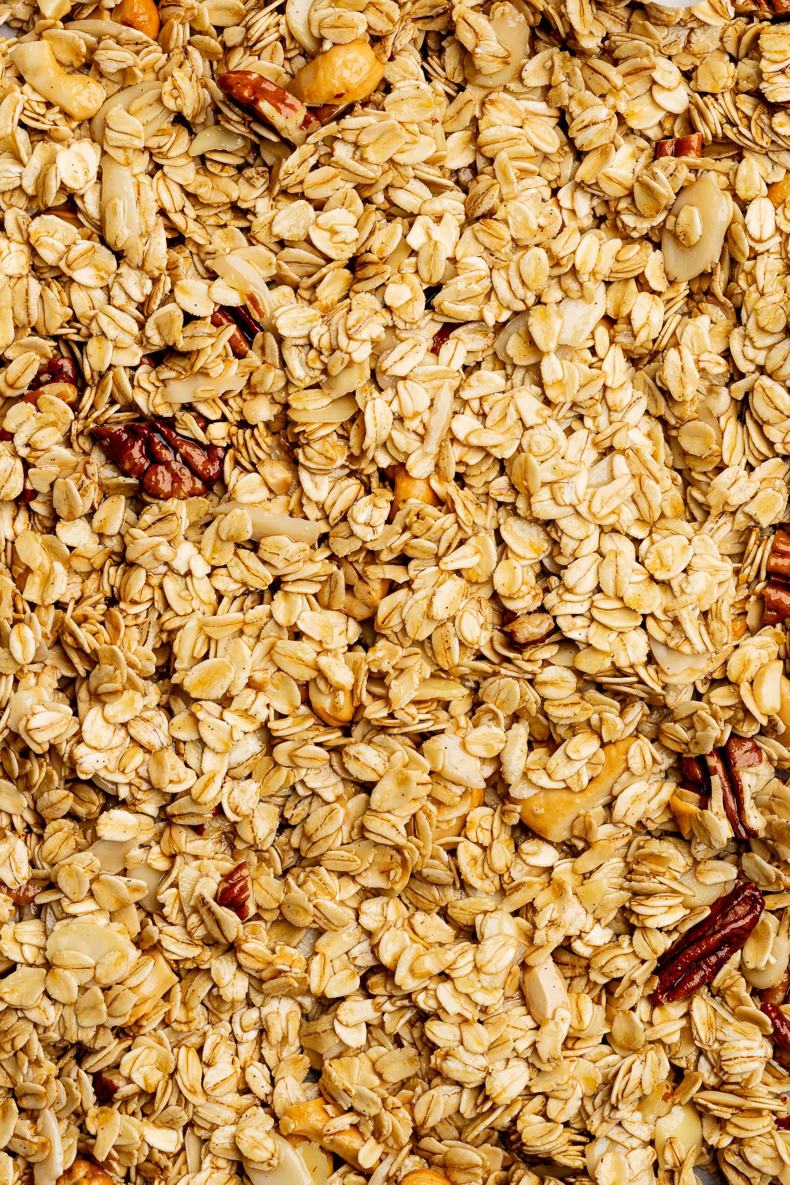 Granola spread out on to a baking sheet before baking.
