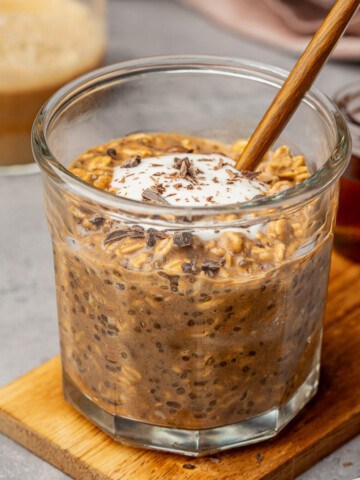 Coffee oats in a glass jar with a dollop of yogurt and chocolate chips as garnish.