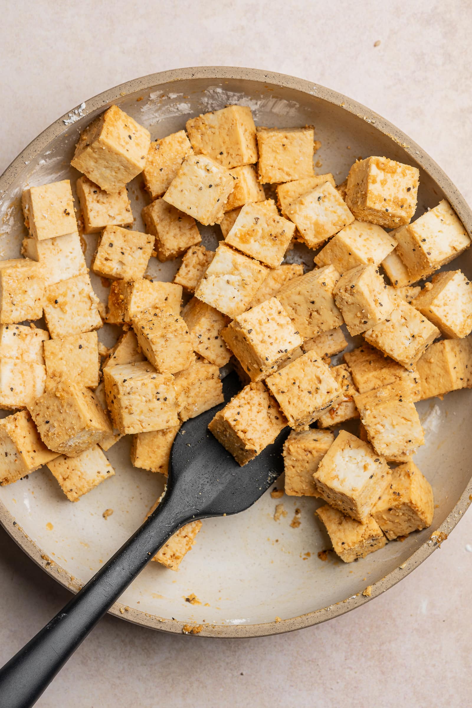 Cubed tofu tossed in seasonings and cornstarch until coated.