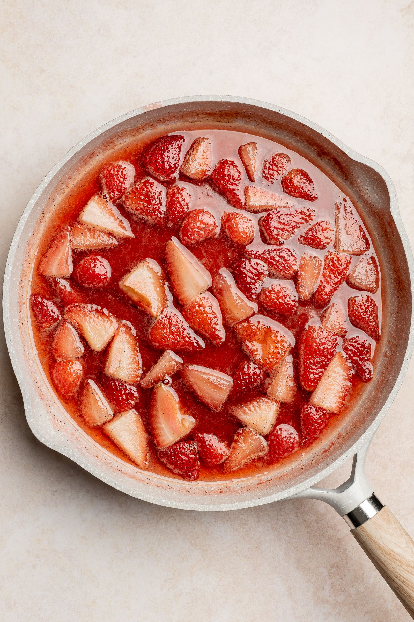 Simmered strawberry simple syrup in a pan.
