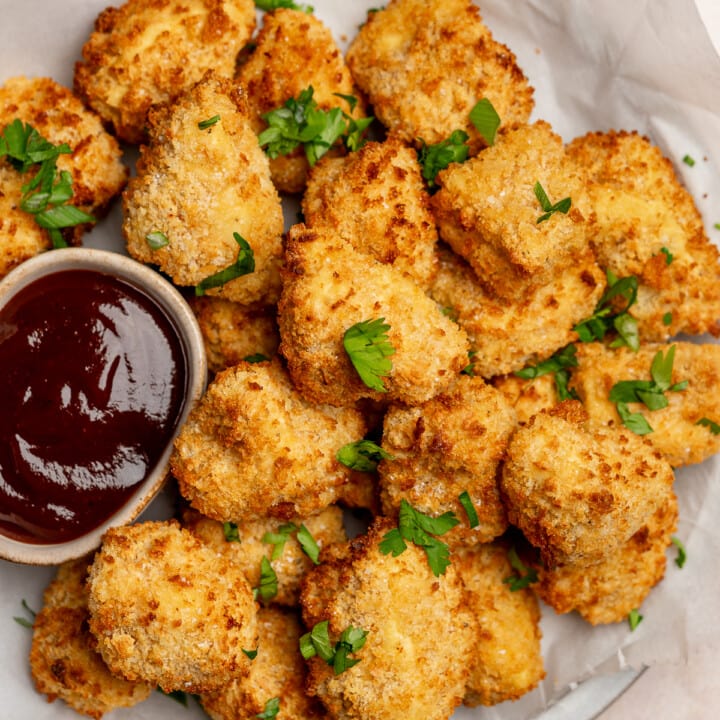Crispy battered tofu on a serving plate with bbq sauce.