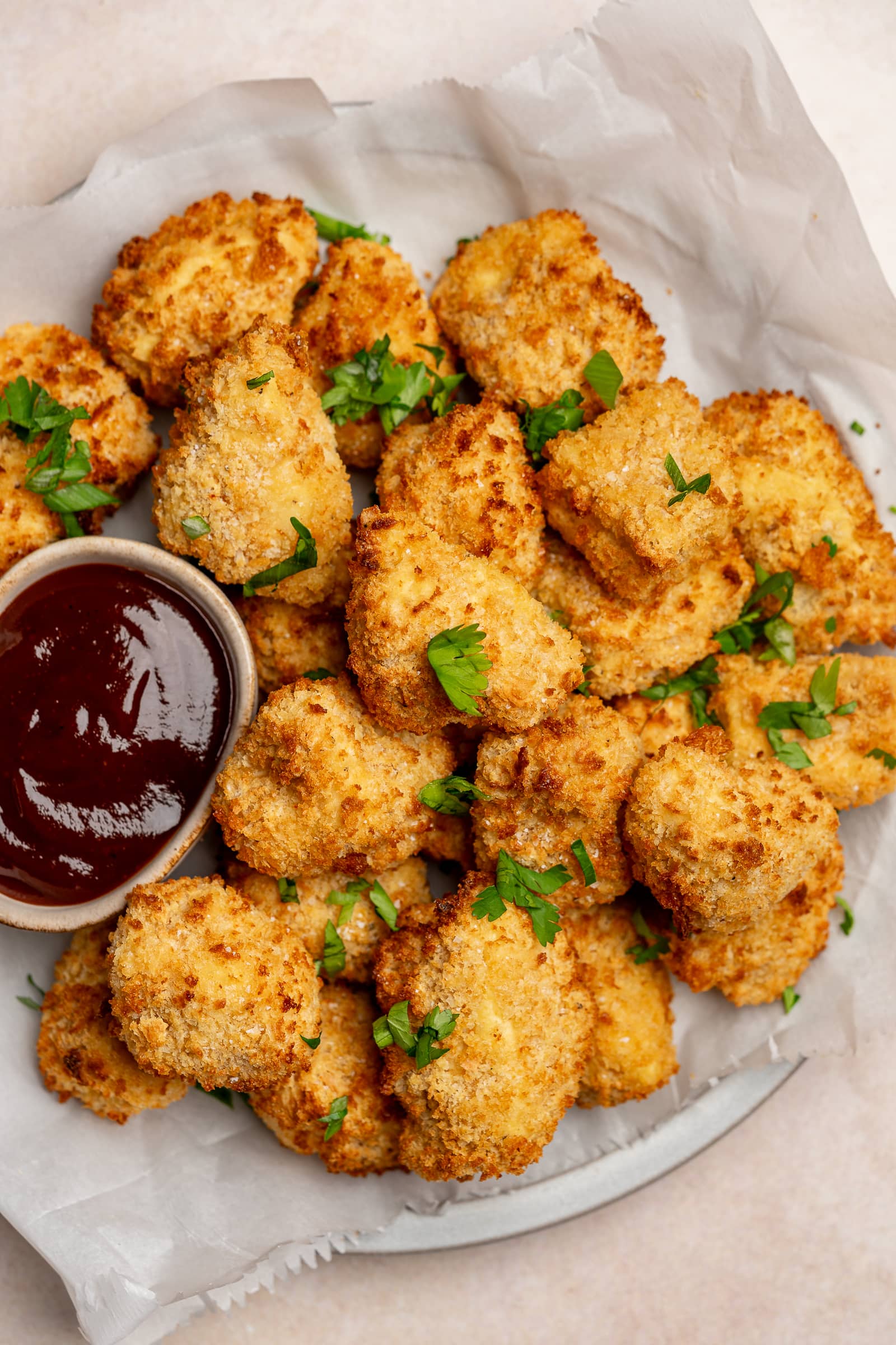 Crispy battered tofu on a serving plate with bbq sauce.