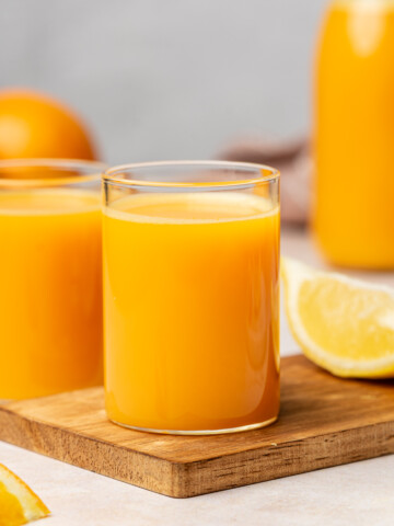 Lemon ginger carrot wellness shots in a shot glass.