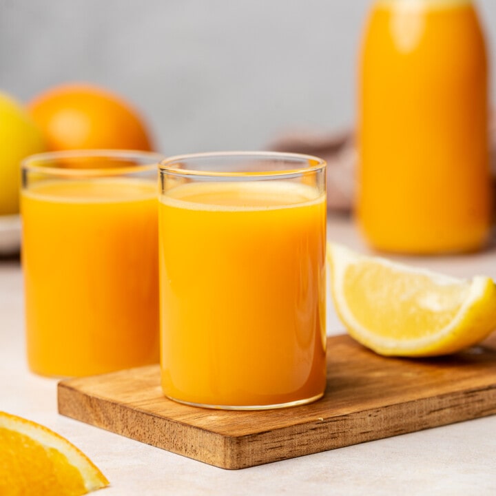 Lemon ginger carrot wellness shots in a shot glass.