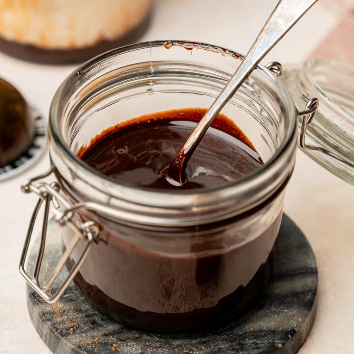 Chocolate sauce for coffee in a jar with a spoon.