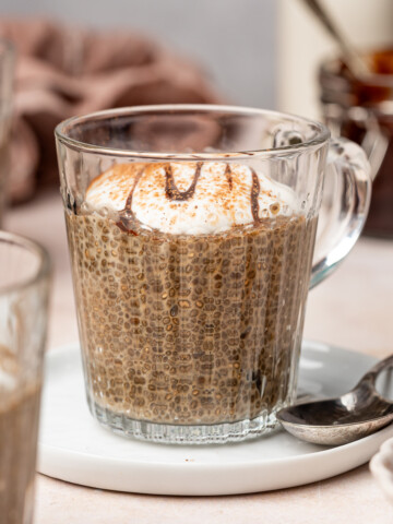 Coffee chia pudding in a glass mug with a dollop of yogurt on top.