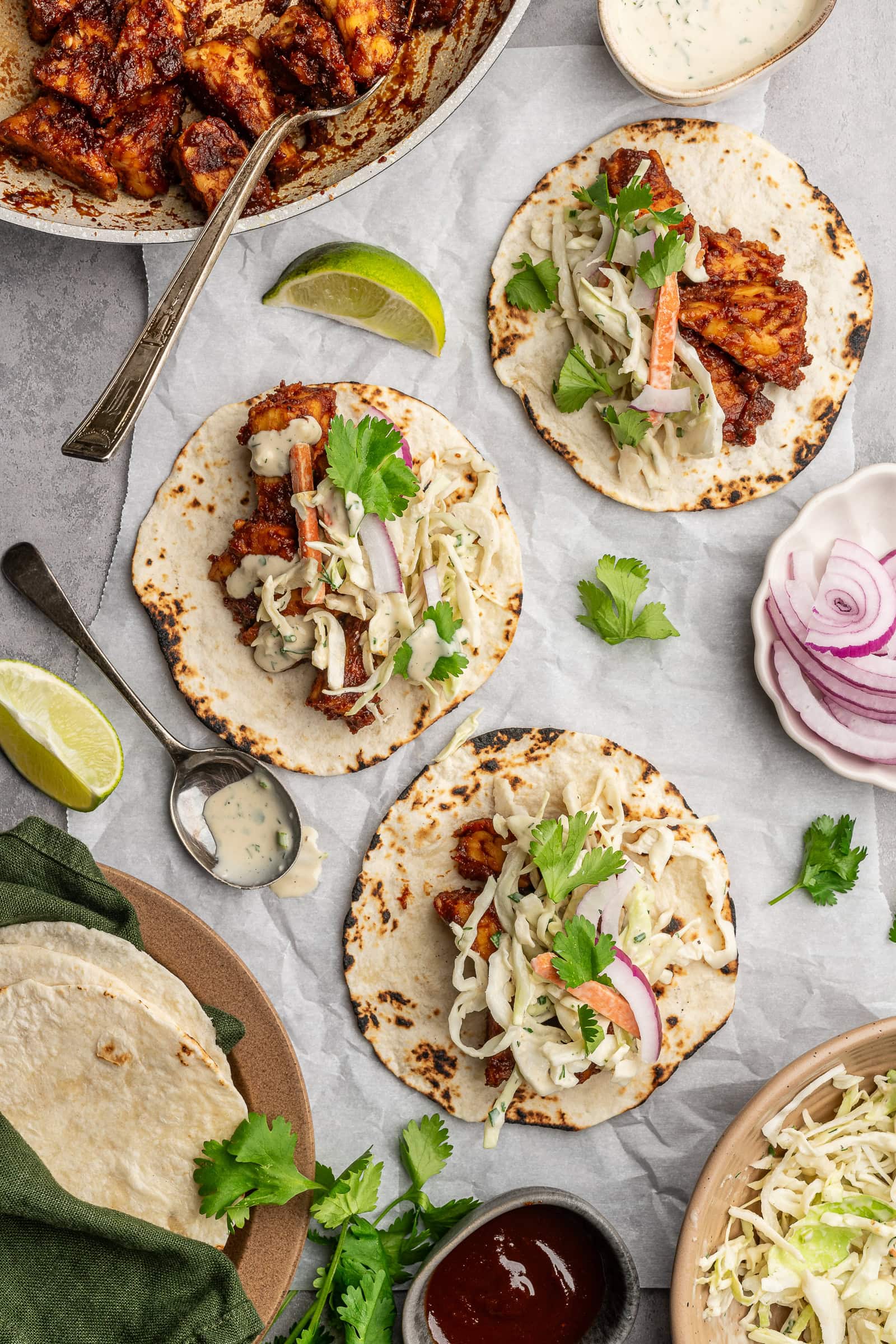 BBQ tempeh on flour tortillas with slaw, red onion, and cilantro.