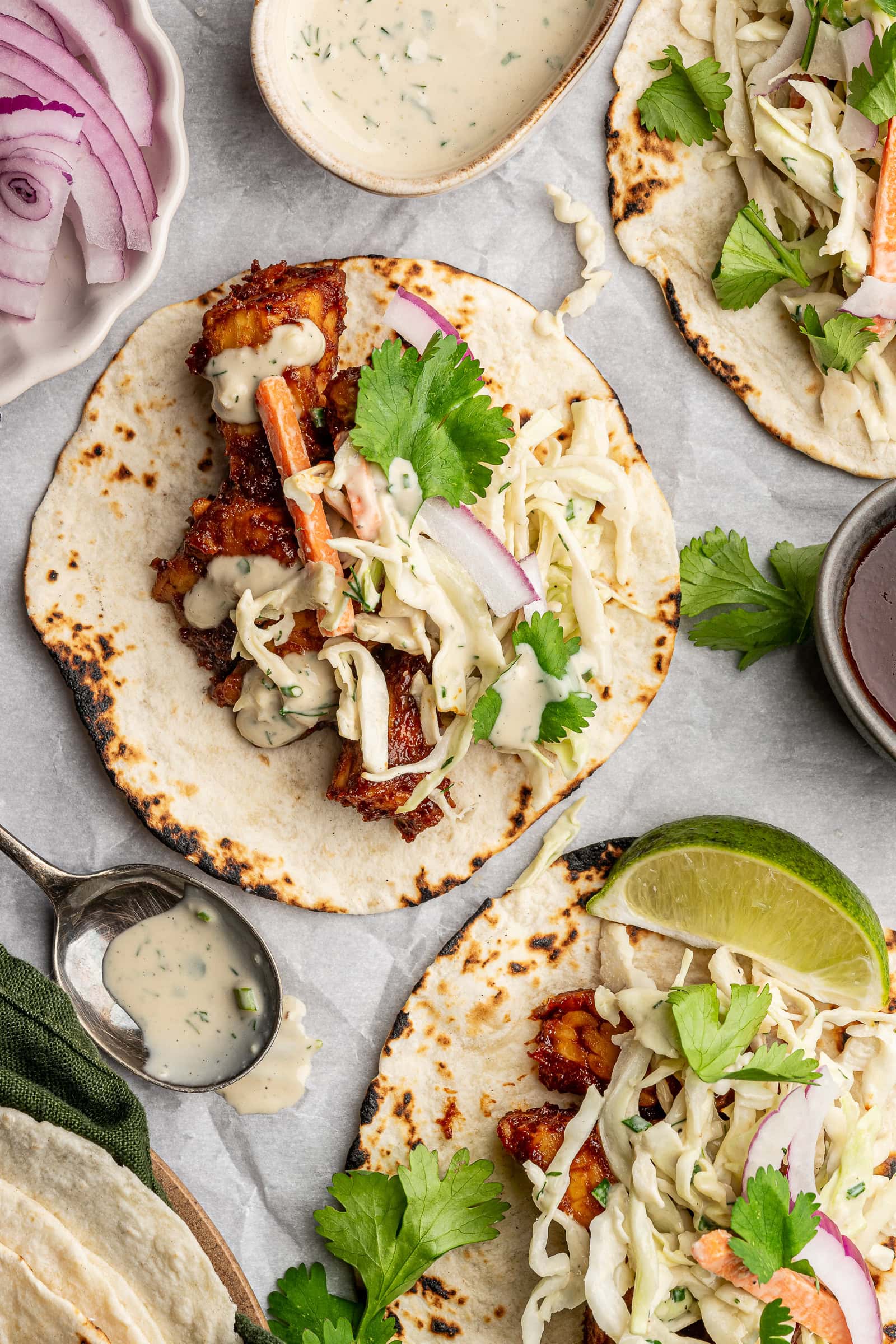 BBQ tempeh on flour tortillas with slaw, red onion, and cilantro.