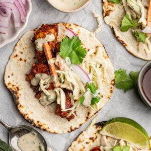BBQ tempeh on flour tortillas with slaw, red onion, and cilantro.