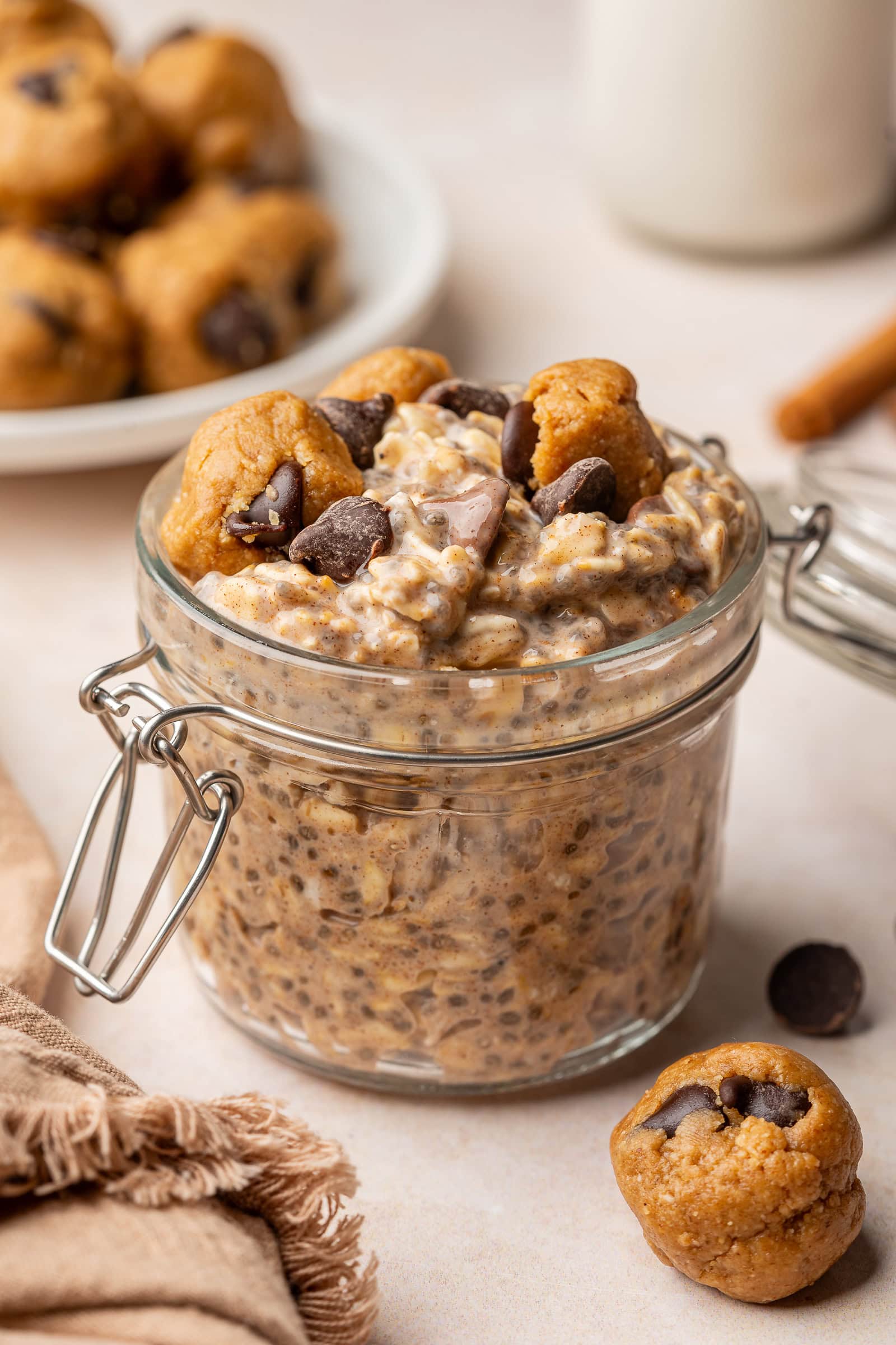 Cookie dough overnight oats in a jar topped with cookie dough pieces and extra chocolate chips.
