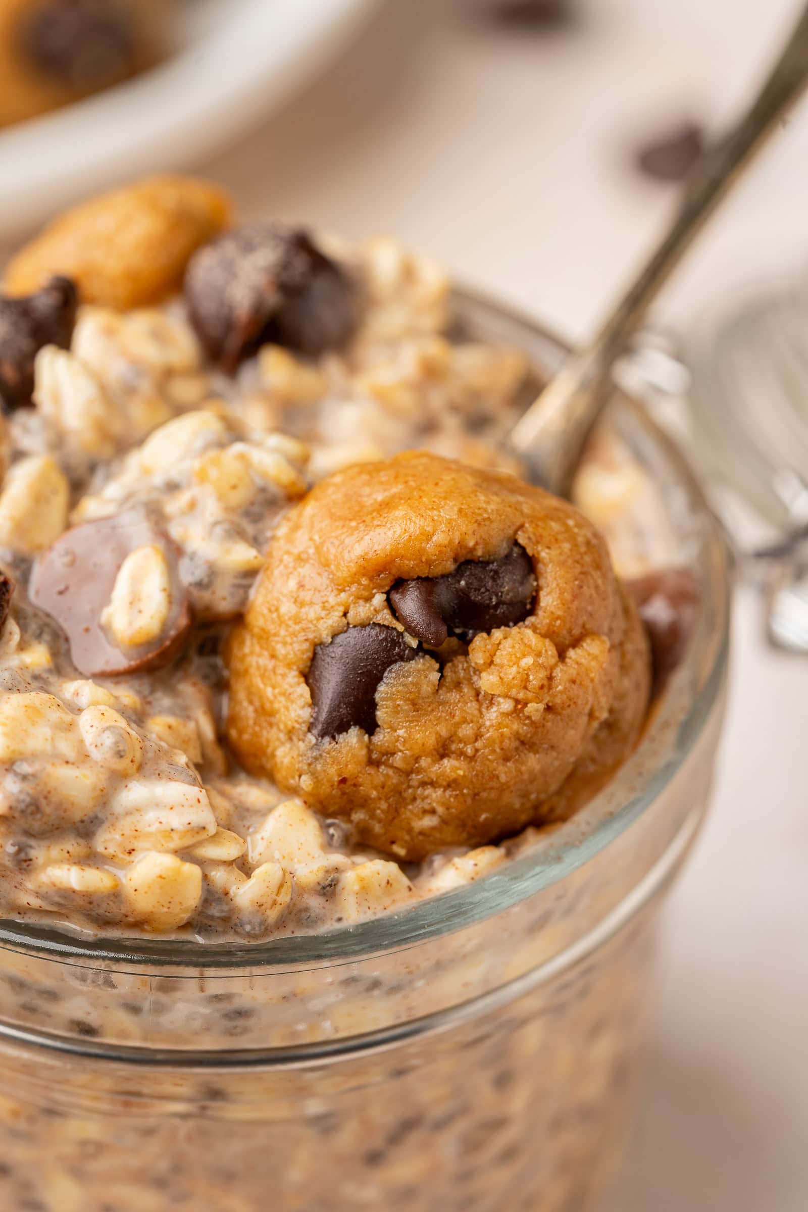 Cookie dough overnight oats in a jar topped with cookie dough pieces and extra chocolate chips.