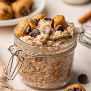 Cookie dough overnight oats in a jar topped with cookie dough pieces and extra chocolate chips.