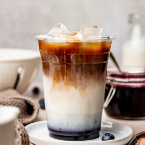 Blueberry iced latte in a plastic coffee cup.