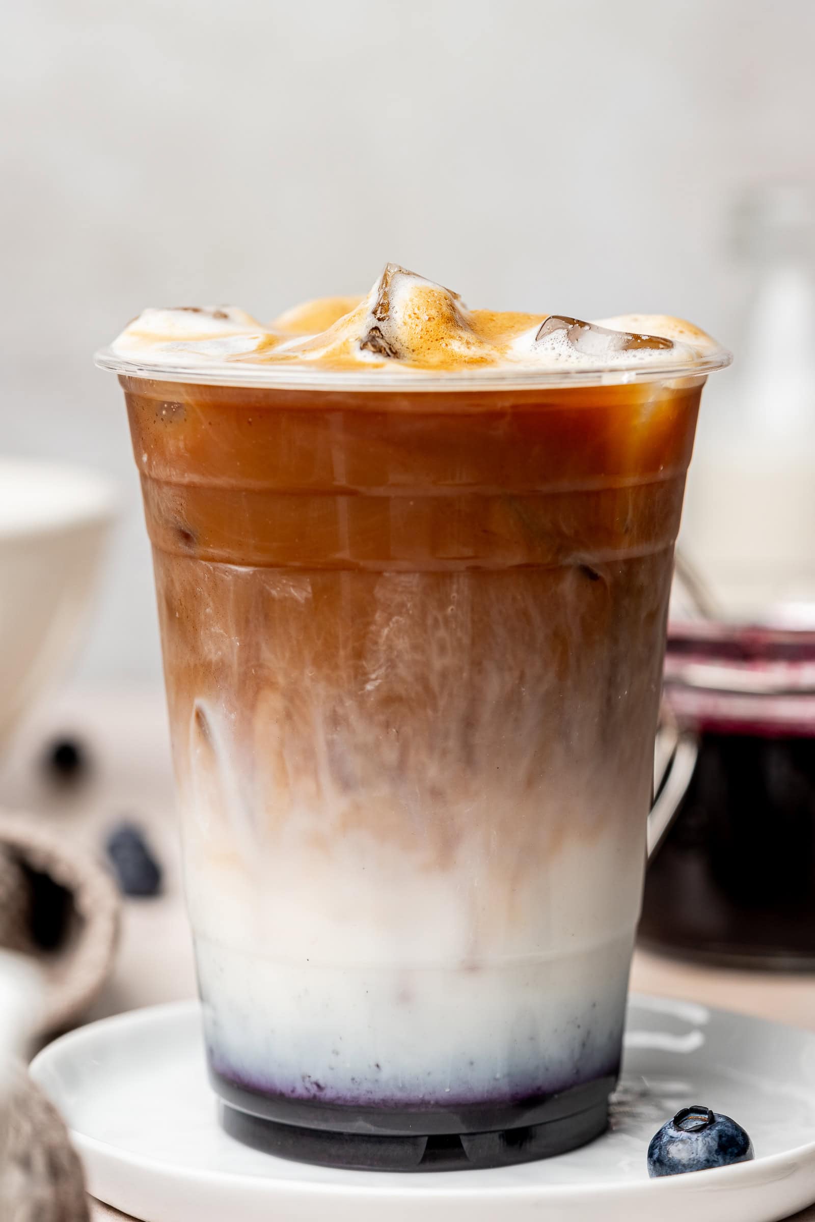 Blueberry iced latte in a plastic coffee cup.