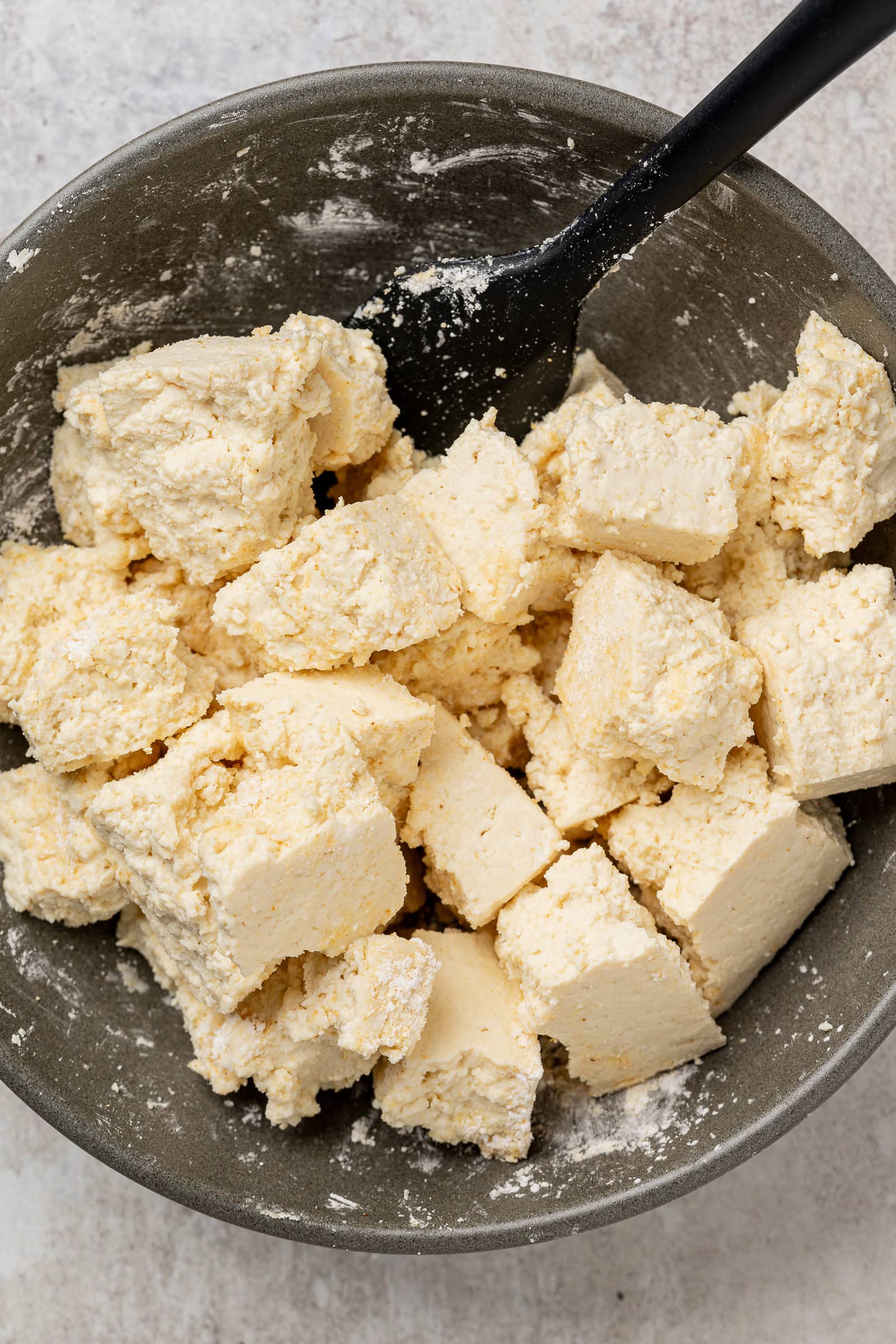 Cornstarch and seasoning coated tofu in a shallow bowl.