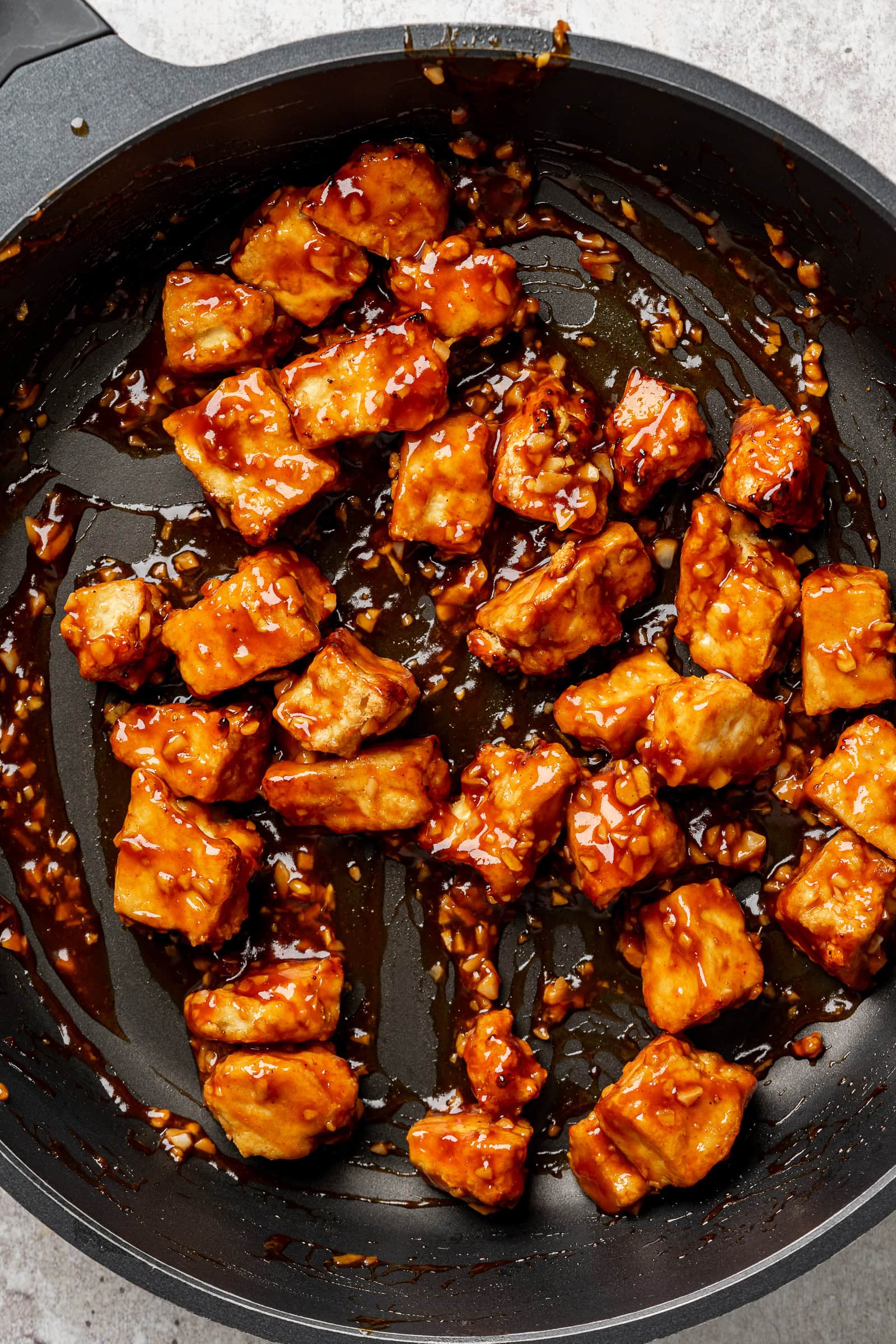 Saucy sticky tofu in frying pan.